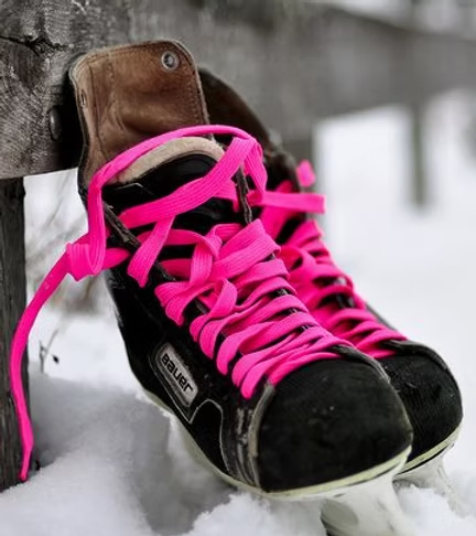 Hockey skates with pink laces on the ice
